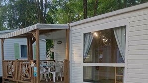 Una casa móvil con terraza de madera y un porche cubierto.