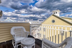 A balcony with wicker furniture and a view of neighboring buildings.