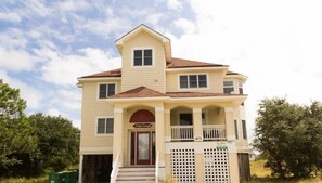 A two-story building with a front porch, a garage, and a small balcony.