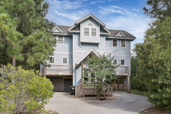 A two-story house with a front porch, a small staircase, and a garage.