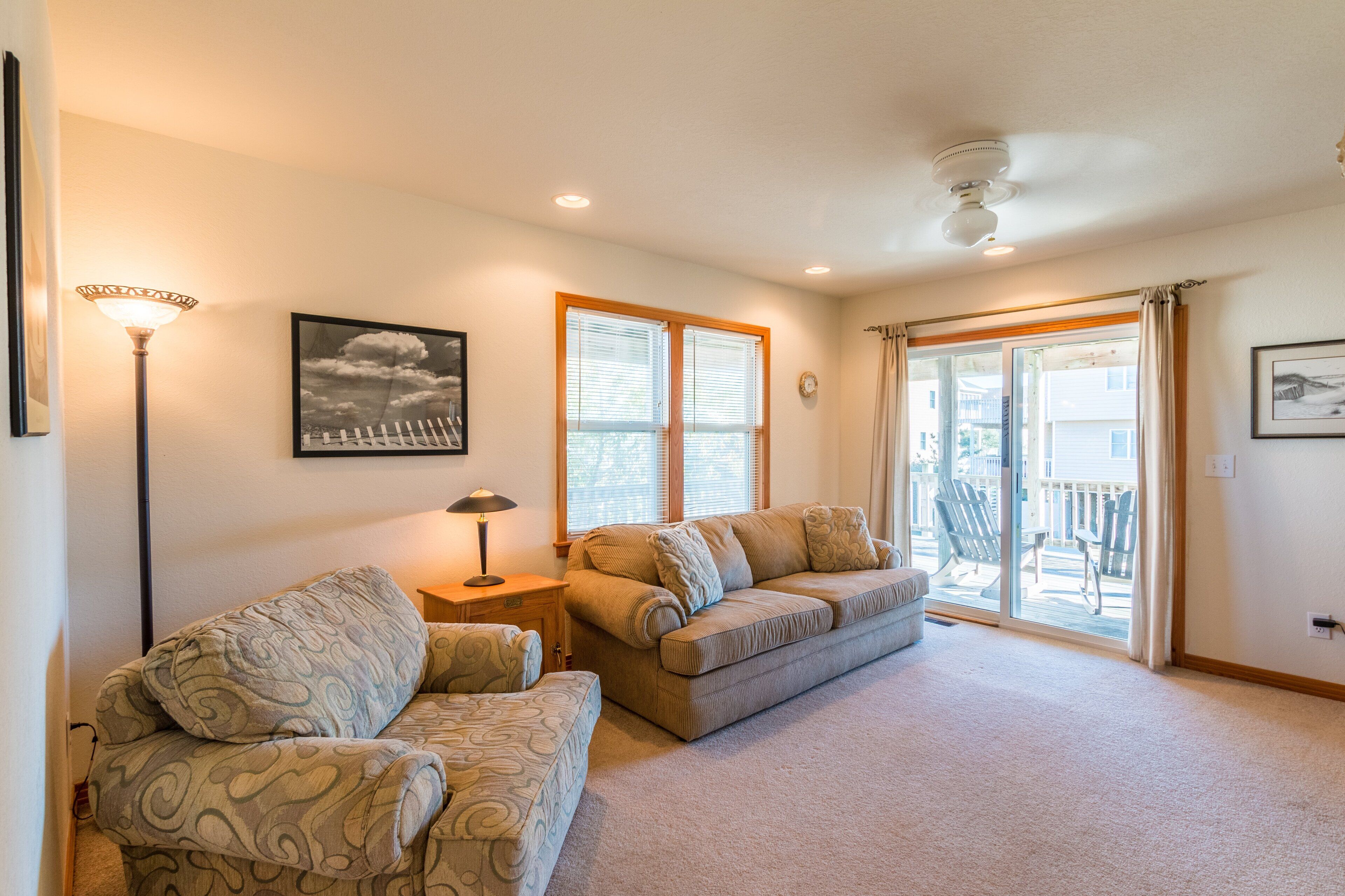 A living room with two sofas, a lamp, and a ceiling fan.