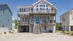 A multi-story building with a central staircase, balconies, and a blue door. - 1618 - Dune Buggy - Walk to Beach | Private Pool & Hot Tub (Corolla)