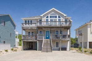 A multi-story building with a central staircase, balconies, and a blue door. - 1618 - Dune Buggy - Walk to Beach | Private Pool & Hot Tub (Corolla)