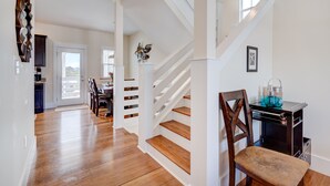 Un interior moderno con una escalera, comedor y cocina.