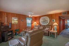 Relax in this inviting living room with a comfortable sofa, TV, and table.