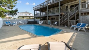 A pool area with lounge chairs and a wooden deck. - 2820 - Dabbling Duck - Spacious Duck Getaway | Pool, Hot Tub & More (Duck)