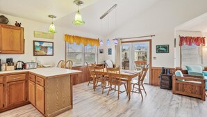 Un'ampia cucina con mobili in legno, un'isola centrale e un'area pranzo con sedie di legno.
