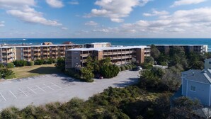 A multi-story parking garage adjacent to a beachfront hotel with a view of the ocean. - 2948 - Duck Nest, Perfect for smaller families or couples with unparalleled ocean views & amenities (Duck)
