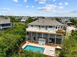 Une maison à deux étages avec une piscine, une terrasse et une vue sur le quartier.