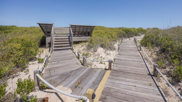 A wooden boardwalk leading to a beach area with a clear sky. - 4104 - Sever's Hideaway, Cozy Coastal Retreat | Walkable Duck Location (Duck)