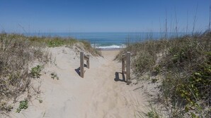 A sandy beach path leading to the ocean with wooden posts on either side. - 4104 - Sever's Hideaway, Cozy Coastal Retreat | Walkable Duck Location (Duck)