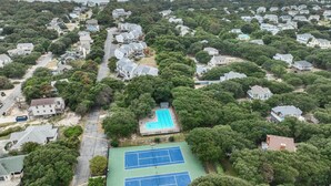 Vista aérea de una zona residencial con casas, piscina y canchas de tenis.