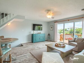 Relax in a spacious living room with a large window offering a view of the outdoors and a comfortable seating area.