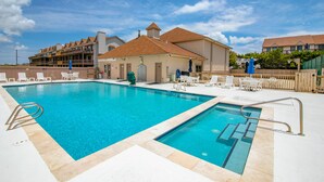 Une piscine divisée en deux zones distinctes, entourée de chaises longues et d’une clôture en bois.