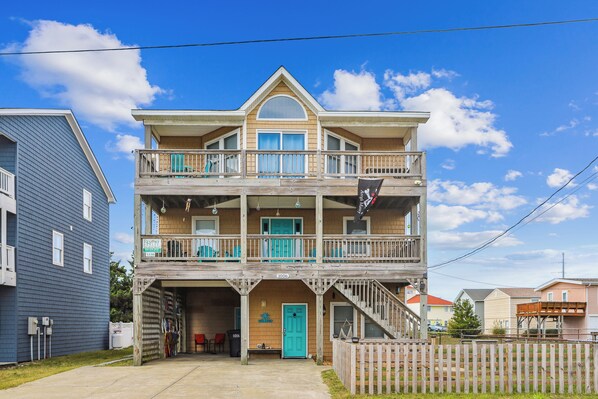 A two-story building with a balcony, a welcome sign, and a number sign.