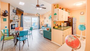 A bright kitchen with a dining area, a ceiling fan, and a globe on the counter.