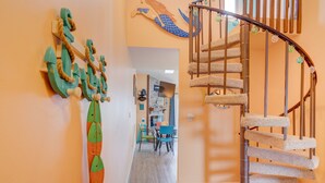 A spiral staircase with a textured carpet, a wooden handrail, and decorative elements.