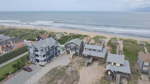 Un quartier résidentiel situé sur la côte, avec des maisons, une plage et une vue dégagée sur l’océan.