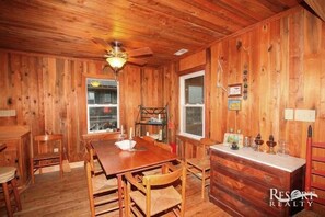 Enjoy meals at the large dining table surrounded by comfortable chairs, with a window offering a view of the outdoors.