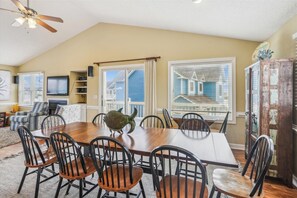 Enjoy meals in this dining area with a large table and comfortable seating for six, offering a view of the surrounding neighborhood.