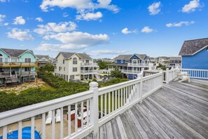 Un quartier résidentiel situé sur la côte, avec des maisons à plusieurs étages dotées de balcons et de terrasses en bois.