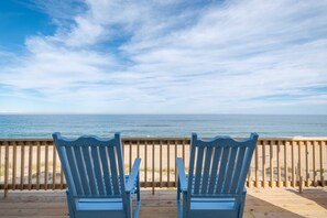Relax on the deck with two Adirondack chairs overlooking the ocean and sandy beach.