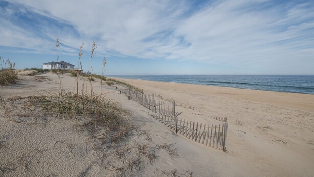 A beach with a wooden fence, a house, and the ocean. - 5793- Beachy Keen - South Nags Head Retreat Steps From Beach (Nags Head)