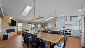 Une cuisine spacieuse avec un grand îlot central, un plancher en bois et des armoires bleu clair.