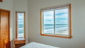 A bedroom with a large window offering a view of the ocean. - 6300- Sea Master, OBX Oceanfront Escape | Jacuzzi & Views (Nags Head)