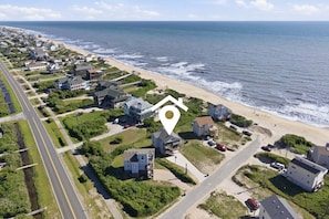 Une zone résidentielle côtière comprenant des maisons, une route et une plage.