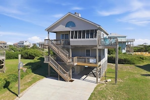 A two-story building with a balcony, a staircase, and a sign indicating it's a resort property.