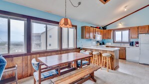 A spacious kitchen with wooden cabinets, a large island, and a view of the outside. - 6504- Eagle's Nest - Quiet Ocean View Escape | Walk to Beach (Nags Head)