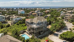 Un immeuble résidentiel à plusieurs étages, doté d’un balcon et d’une piscine en premier plan.