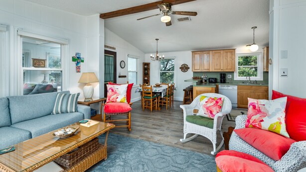 A spacious living area with a sofa, chairs, a dining table, and a kitchen in the background. - 7563- Sea Dreams, 200 Yards to Beach | Pool Access in Avon (Avon)