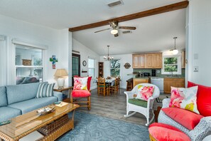A spacious living area with a sofa, chairs, a dining table, and a kitchen in the background. - 7563- Sea Dreams, 200 Yards to Beach | Pool Access in Avon (Avon)