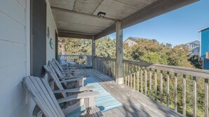 Une véranda couverte, dotée de balustrades en bois, d’où l’on peut admirer les maisons voisines.