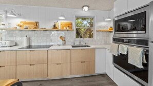A modern kitchen with white cabinets, a built-in oven, and a window. - 7850- Nepenthe - Charming Frisco Getaway Near The Beach (Frisco)