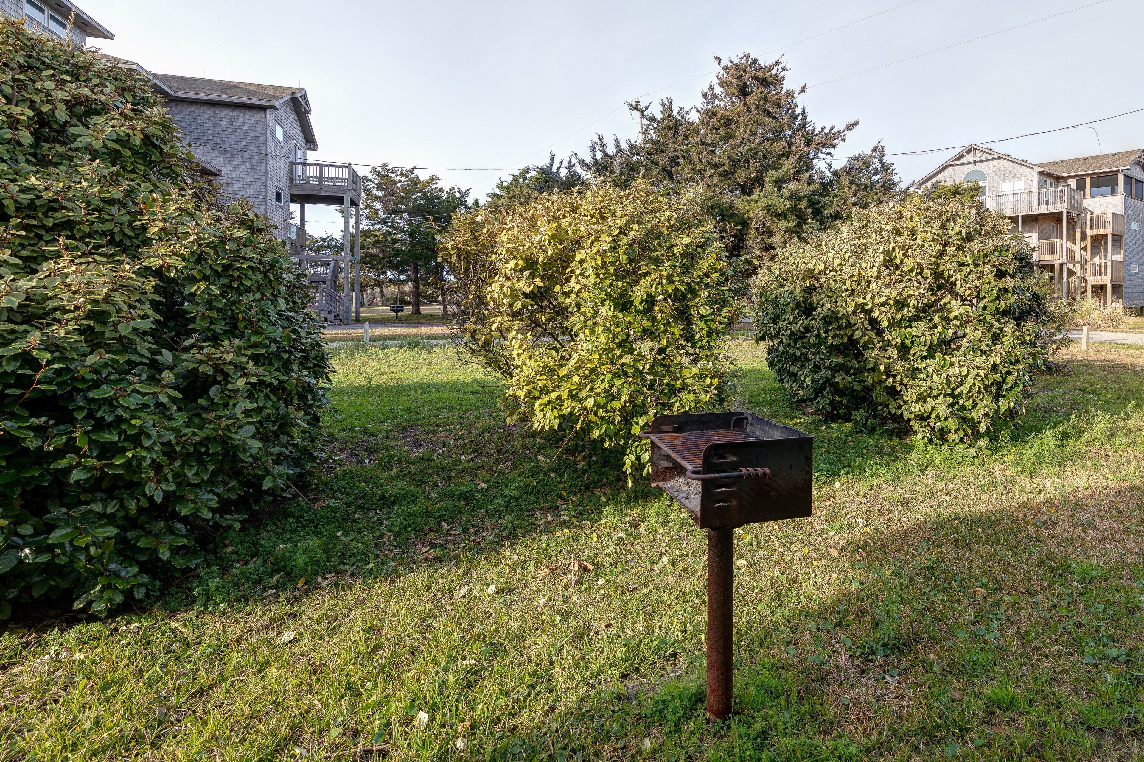 A residential area with a grassy lawn, a metal mailbox, and houses in the background.