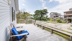 A wooden deck with a bench and a railing, overlooking a grassy area and a tree. - 7950- Ocean, | Coastal Hatteras Escape | Walk to Beach (Hatteras)