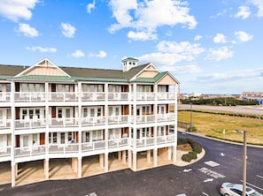 A multi-story hotel with balconies, a green roof, and a parking area with a fire lane.