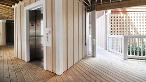 A wooden deck with an elevator and a white fence. - C213-Sound and Sea 213, | Soundfront | Sugar Creek | Nags Head | Sleeps 6 (Nags Head)