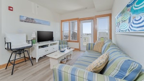 A living room with a sofa, TV, and a small table. - C213-Sound and Sea 213, | Soundfront | Sugar Creek | Nags Head | Sleeps 6 (Nags Head)