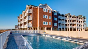 A swimming pool with a deck, surrounded by multi-story buildings with balconies. - C213-Sound and Sea 213, | Soundfront | Sugar Creek | Nags Head | Sleeps 6 (Nags Head)