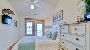 A bedroom with a bed, dresser, television, and a balcony door. - C309-Sounds Good 309 - Soundfront Nags Head Condo With Sunsets (Nags Head)