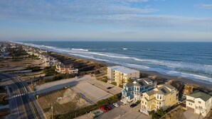 Vista aérea de una zona costera con playa, océano y edificios residenciales.