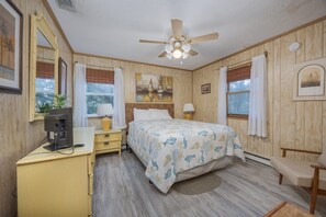 A bedroom with a bed, a desk, a chair, a ceiling fan, and a window with curtains. - 7602- Drydock, Dog-Friendly Avon Cottage Near the Beach (Avon)