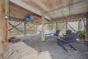 A covered outdoor area with wooden flooring, seating, and a swing. - 7602- Drydock, Dog-Friendly Avon Cottage Near the Beach (Avon)