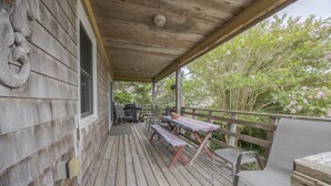 A wooden deck with a covered area, a grill, and outdoor seating. - 7602- Drydock, Dog-Friendly Avon Cottage Near the Beach (Avon)