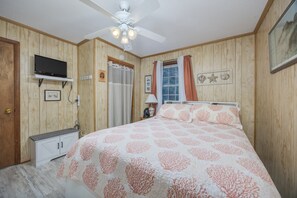 A bedroom with a bed, a ceiling fan, a television, and a window with curtains. - 7602- Drydock, Dog-Friendly Avon Cottage Near the Beach (Avon)
