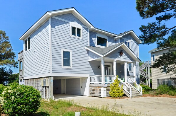 A two-story house with a covered porch and a staircase leading to the second floor.